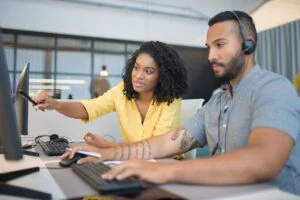 A man and a woman looking at a computer